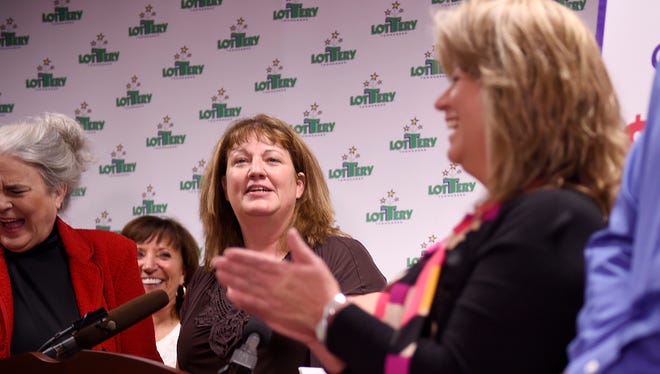 Amy O'Neal, center, of North American Stamping Group in Portland, Tenn., will share the winning $420 million Powerball prize with 19 co-workers. The group was introduced in Nashville on Tuesday, Nov. 29, 2016, as the winners of the Saturday, Nov. 26, 2016, drawing.