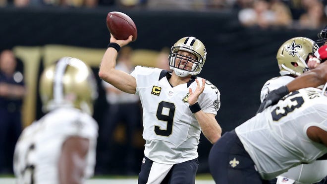 Saints quarterback Drew Brees (9) drops back to pass during the first half against the Falcons.