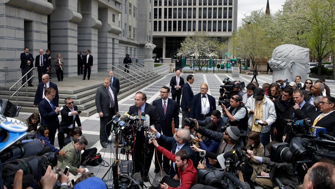 David Wildstein, center, listens as his attorney Alan Zegas, center left at podium, addresses the media as they leave federal court after a hearing Friday, May 1, 2015, in Newark, N.J. Wildstein, a former ally of Gov. Chris Christie pleaded guilty Friday to helping engineer traffic jams at the George Washington Bridge in a political payback scheme he said also involved two other Christie loyalists. But he did not publicly implicate Christie himself.   (AP Photo/Mel Evans)