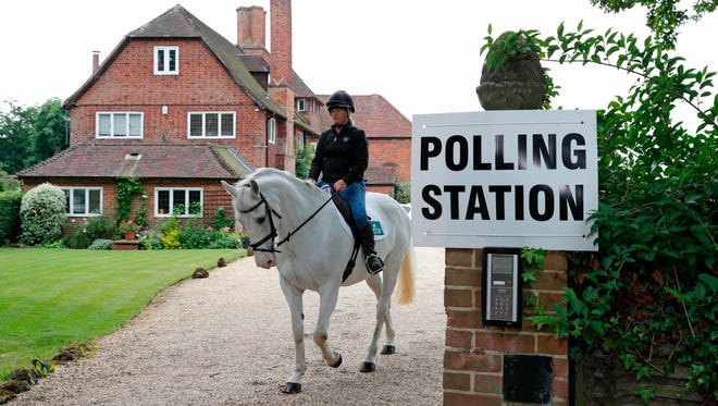Sophie Allison, riding her horse Splash, rides out of the driveway of a private residence, set up as a polling station, near Reading, west of London.