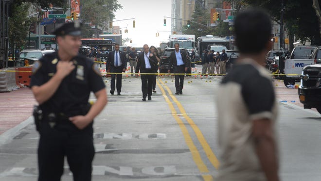 New York Gov. Andrew Cuomo, center right, walks down 23rd Street where an explosive device went off last night on the left side of the mid-block section of Chelsea. Law enforcement agencies are conducting investigations.