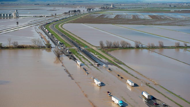 In this view looking north, flood water crosses over Interstate 5 at Williams backing up traffic in both north and southbound lanes for hours on Feb. 18, 2017, in Williams, Calif. Northern California and the San Francisco Bay Area were facing a weekend return of heavy rain and winds that lashed them earlier in the week before the storm moves out.