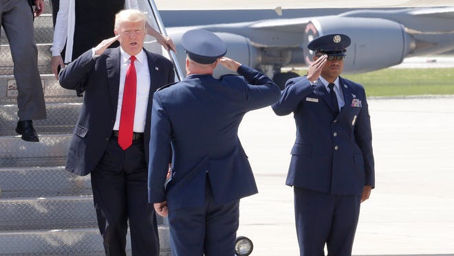 President Donald Trump salutes a member of the military upon arrival at the 128th Air Refueling Wing at 1919 E Grange Avenue near General Mitchell International Airport in Milwaukee.