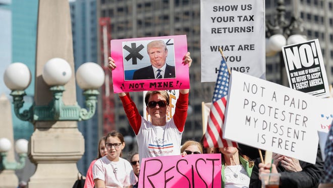 Protestors display signs in Chicago during the 'Not My Presidents Day' rally.
