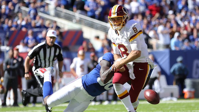 Washington Redskins quarterback Kirk Cousins (8) fumbles the ball as New York Giants defensive end Jason Pierre-Paul (90) defends during the second quarter at MetLife Stadium.