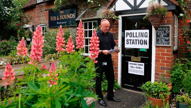 Polling station inspector Paul Howden arrives at a pub, set up as a polling station, in Cristmas Common, near Oxford, west of London, on June 8, 2017, as Britain holds a general election.