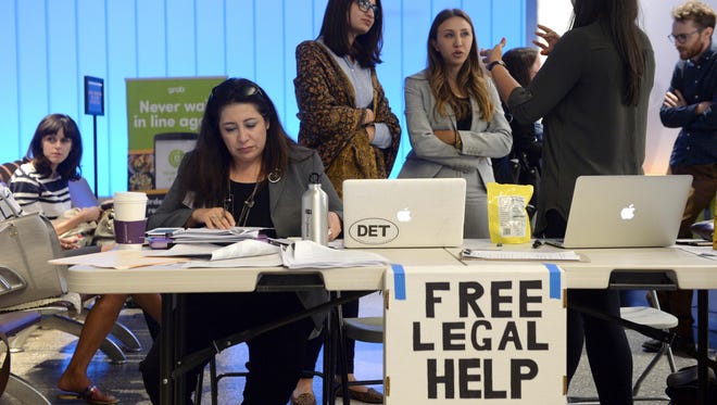 Immigration attorney Maggie Castillo, left, of the American Immigration Lawyers Association, offers her services to travelers affected by President Trump's travel ban at Los Angeles International Airport on June 29, 2017.