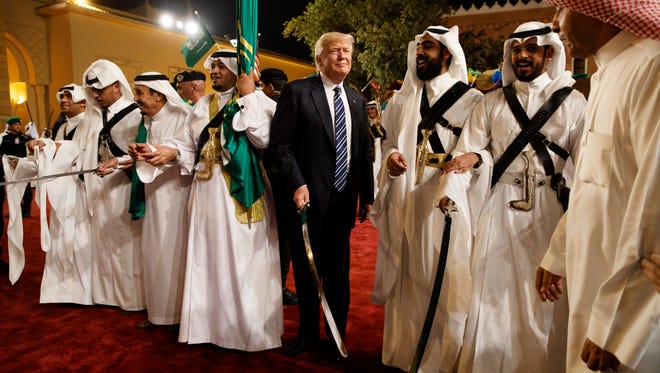 President Trump holds a sword and sways with traditional dancers during a welcome ceremony at Murabba Palace on May 20, 2017, in Riyadh.