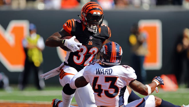Cincinnati Bengals running back Jeremy Hill (32) scores a touchdown after being tackled by Denver Broncos strong safety T.J. Ward (43) in the first half at Paul Brown Stadium.