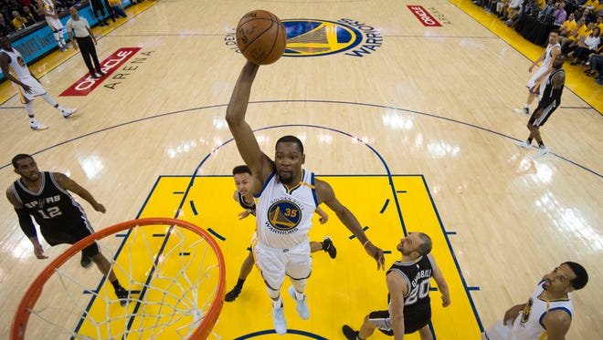Golden State Warriors forward Kevin Durant dunks the basketball against San Antonio Spurs guard Manu Ginobili during the second half in Game 1 of the Western Conference finals of the 2017 NBA Playoffs.