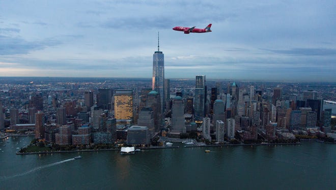 In this undated photo provided by JetBlue, the carrier's 'Blue Bravest' liveried aircraft is seen flying over the Manhattan skyline.