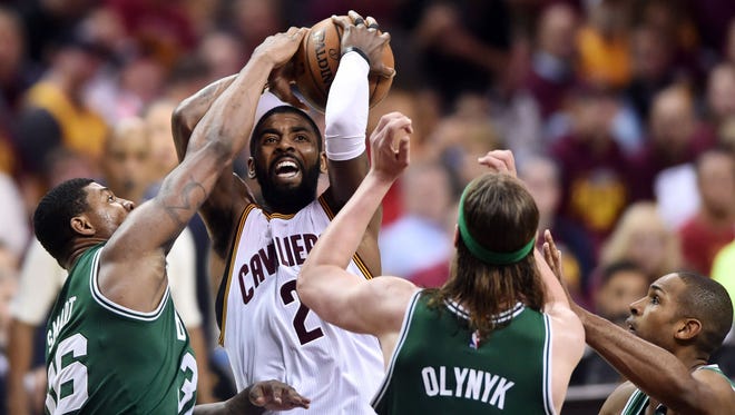 Kyrie Irving (2) drives to the basket between Boston Celtics guard Marcus Smart (36) and center Kelly Olynyk (41) during the second half in Game 4 of the Eastern Conference finals.