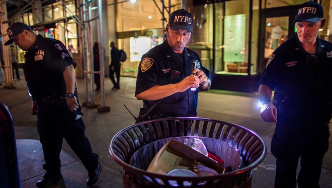 Police officers look for suspicious packages along Fifth Avenue near the scene of an explosion on West 23rd Street and 6th Avenue in Manhattan's Chelsea neighborhood, in New York, early Sunday, Sept. 18, 2016.