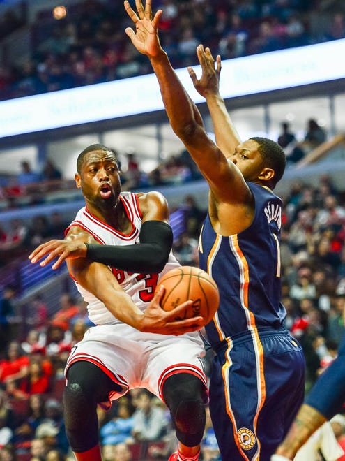 Dwyane Wade passes the ball around Kevin Seraphin.