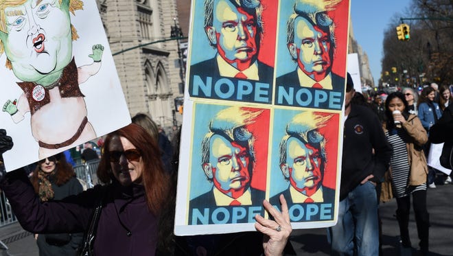 Protestors carry signs as they march  in New York City during a 'Not My President's Day' rally on Feb. 20, 2017.