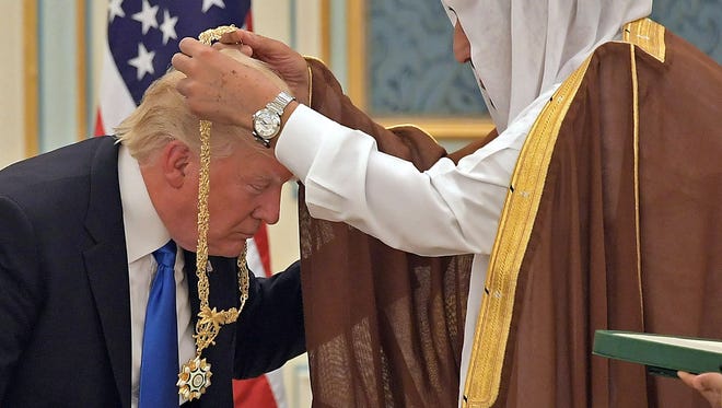 President Trump (C) receives the Order of Abdulaziz al-Saud medal from Saudi Arabia's King Salman bin Abdulaziz al-Saud (R) at the Saudi Royal Court in Riyadh on May 20, 2017.