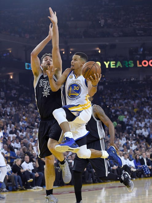 Stephen Curry goes up for a layup and gets fouled by Pau Gasol.