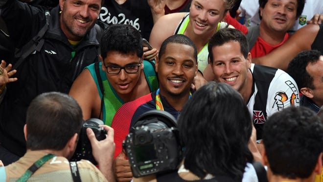 Carmelo Anthony poses for pictures with fans after USA won the gold medal in the Rio Olympics.