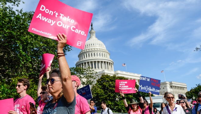 Protesters march around the U.S. Capitol to show their opposition to the American Health Care Act on June 28, 2017.