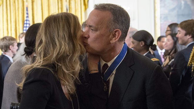 Actor Tom Hanks greets his wife, Rita Wilson, as he leaves after President Obama presented him with the Presidential Medal of Freedom.