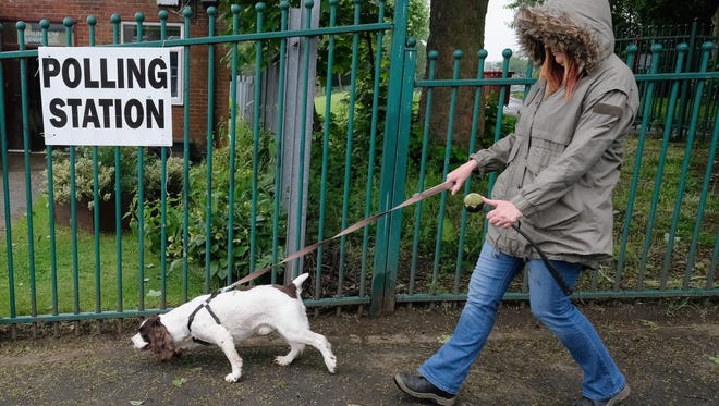 A woman walks her dog past a polling station in Carlin How.