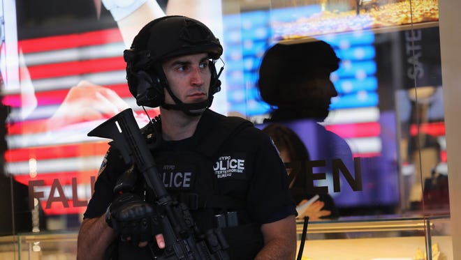 Heavily armed policemen stand guard in Times Square on September 19, 2016 in New York City.