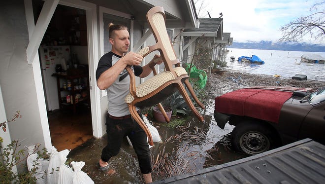 Michael Angel moves furniture from his home in Lakeport, Calif., on Feb. 21, 2017.