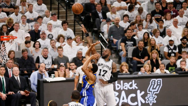 San Antonio Spurs shooting guard Jonathon Simmons shoots the ball over Golden State Warriors point guard Shaun Livingston during the first half in game three of the Western conference finals of the NBA Playoffs at AT&T Center.