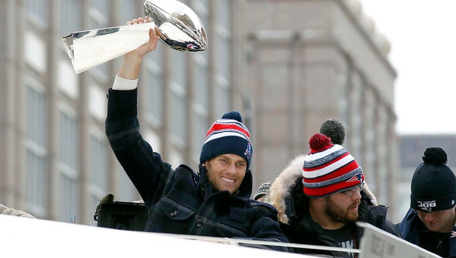Brady holds up the Vince Lombardi Trophy during the Super Bowl XLIX victory parade.