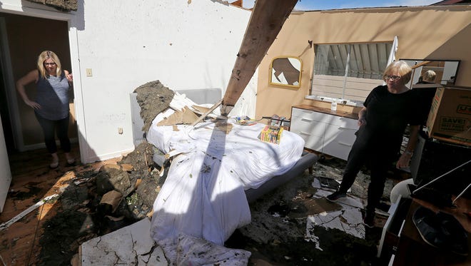 Mikela Kinnison, left, and her mother Ilona show the damage to the bedroom at Kinnison's home in San Antonio after tornadoes moved through the area late Sunday night.