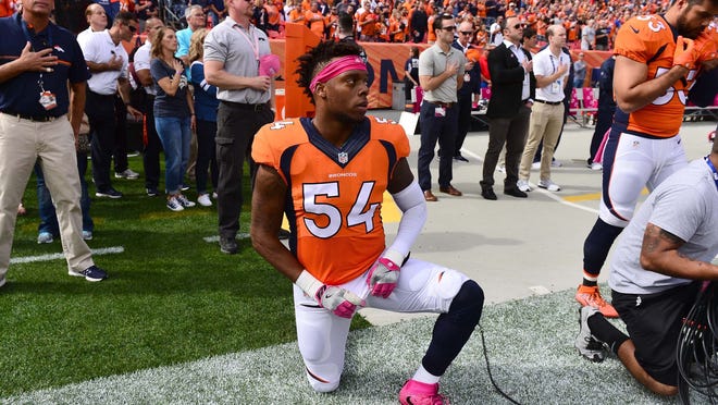 Denver Broncos inside linebacker Brandon Marshall (54) kneels during the national anthem before the start of the game against the Atlanta Falcons at Sports Authority Field at Mile High.