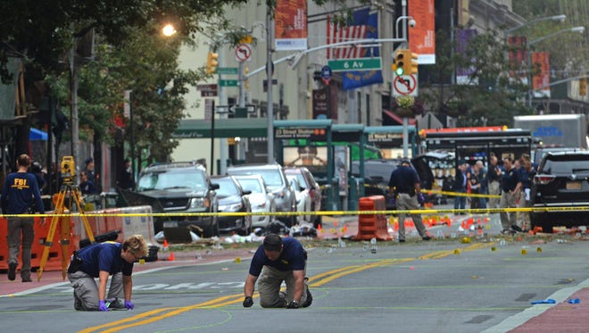 Law enforcement investigators examine the scene of an explosion on West 23rd Street Sept. 18, 2016, in New York City.