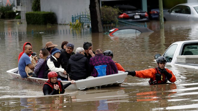 Rescue crews take out residents from a flooded neighborhood in San Jose on Feb. 21, 2017.