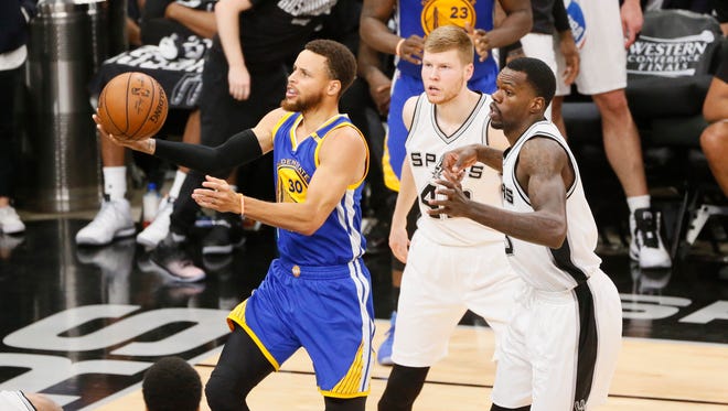 Golden State Warriors point guard Stephen Curry drives to the basket past San Antonio Spurs small forward Davis Bertans and Dewayne Dedmon during the second half in Game 4 of the Western Conference finals.