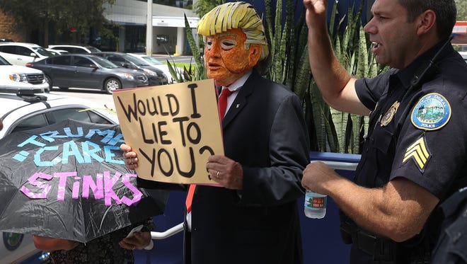 Glenn Terry, dressed as President Donald Trump, joins with other protesters at U.S. Sen. Marco Rubio's (R-FL) office on June 28, 2017 in Doral, Florida. The protesters are demanding Rubio vote against the Senate health care proposal.