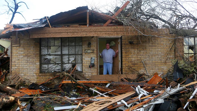 Greg Goza stands in the doorway of his 90-year-old mother-in-law's home after severe weather swept through a neighborhood in north central San Antonio on Feb. 20, 2017. His mother-in-law was not hurt.