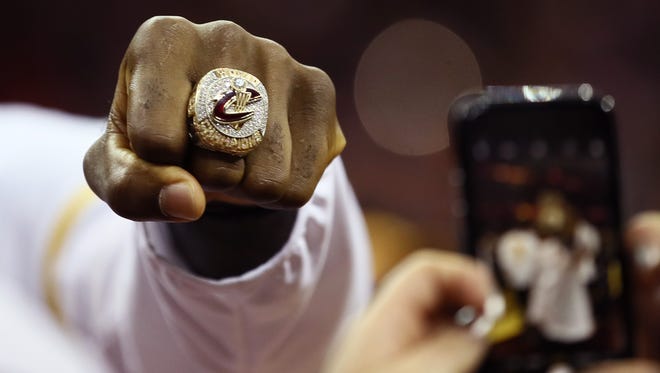 LeBron James shows off his championship ring before Cleveland's opening game against the New York Knicks.