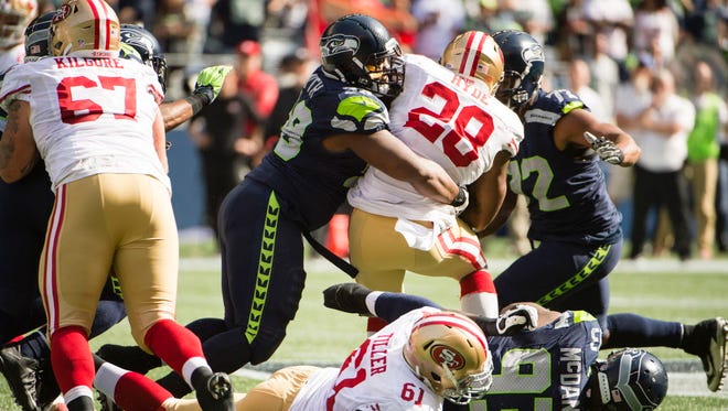 Seahawks defensive tackle Garrison Smith (98) tackles 49ers running back Carlos Hyde (28) during the second quarter.
