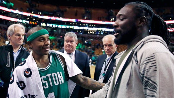 Isaiah Thomas shakes hands with New England Patriots running back LeGarrette Blount.