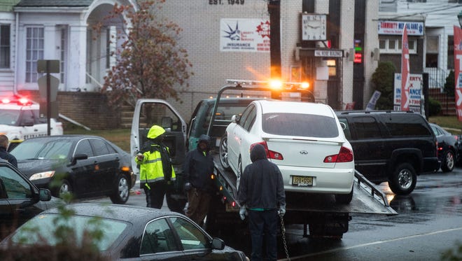 Law enforcement officials tow a car in Elizabeth, N.J. in connection with a series of bombs found in New York and New Jersey, on Sept. 19, 2016.