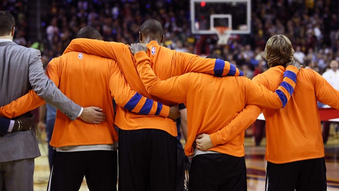 The New York Knicks embrace during the national anthem before their opening night game against the Cleveland Cavaliers.