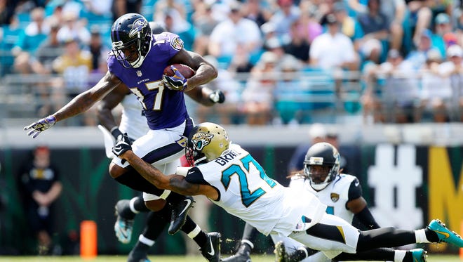 Baltimore Ravens wide receiver Mike Wallace (17) runs the ball after a catch in the first quarter as Jacksonville Jaguars cornerback Dwayne Gratz (27) defends at EverBank Field.