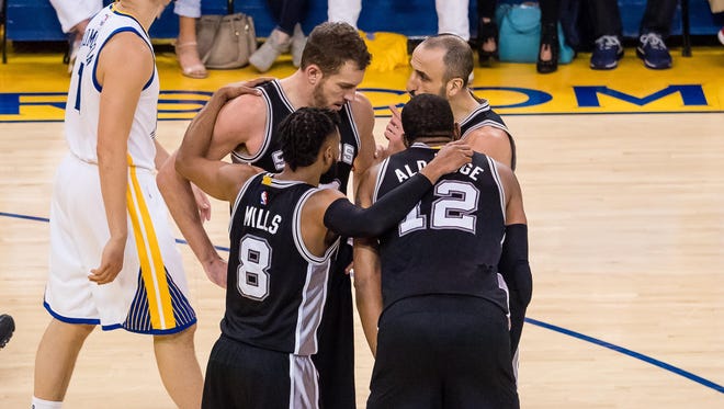 San Antonio Spurs guard Patty Mills, forward David Lee, guard Manu Ginobili and forward LaMarcus Aldridge huddle ahead of Golden State Warriors guard Klay Thompson during the second quarter in Game 1 of the Western Conference finals.