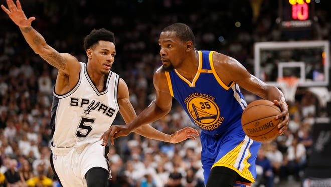 Golden State Warriors small forward Kevin Durant drives to the basket while guarded by San Antonio Spurs point guard Dejounte Murray during the second half in game three of the Western conference finals of the NBA Playoffs.