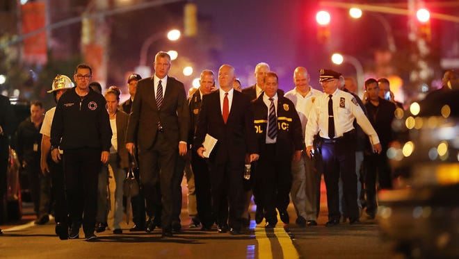 New York Police Commissioner James O'Neill (center right) and Mayor Bill de Blasio (center left) walk into a press conference as police, firefighters and emergency workers gather at the scene of an explosion in Manhattan on September 17, 2016 in New York City.