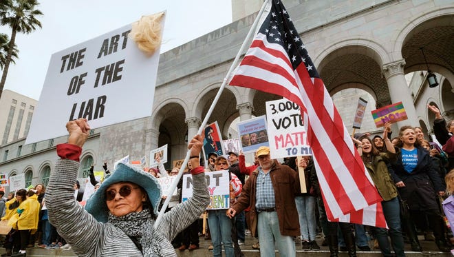 Anita Venegas stands with other protesters on the steps outside of Los Angeles City Hall. Several hundred people gathered in front of Los Angeles City Hall to express their opposition to President Donald Trump and take part in a 'Not My President's Day' rally.