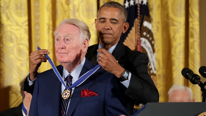President Barack Obama awards the Presidential Medal of Freedom to broadcaster and National Baseball Hall of Fame inductee Vin Scully.