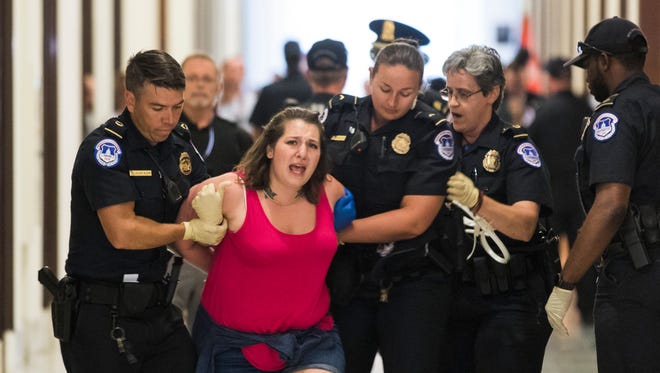 Protestors are arrested outside the office of Sen. Pat Toomey, R-Pa., while lobbying against the Senate Republican's health care bill in Washington on June 28, 2017. After more senators said they would not offer support, senate Republicans yesterday announced they would delay a vote on their revised health care bill.