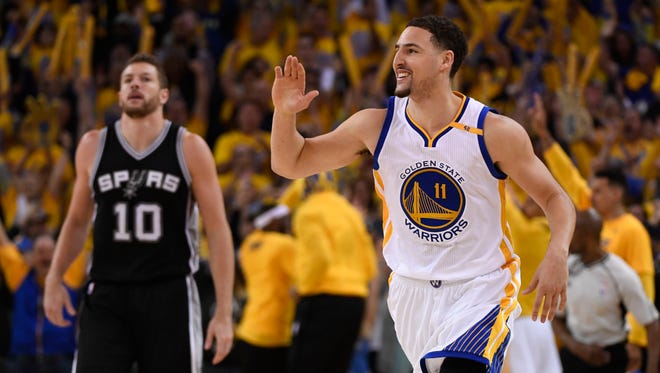 Golden State Warriors guard Klay Thompson celebrates in front of San Antonio Spurs forward David Lee during the third quarter in Game 1 of the Western Conference finals.