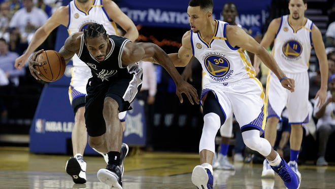 Kawhi Leonard recovers a loose ball in front of Stephen Curry.